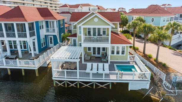 A waterfront property with a dock, multiple decks, and a swimming pool. - Stunning Lake Views in Miramar! Golf Cart, Splash Pool, Private Beach Access! (Miramar Beach)