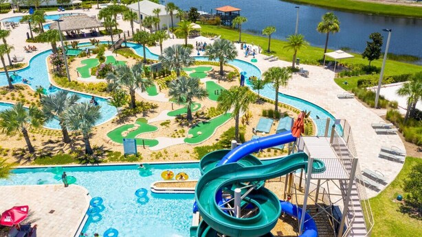 A water park with a large pool, multiple slides, and a golf course area. - 3121-108 Resort Lake View Disney Universal Orlando (Kissimmee)