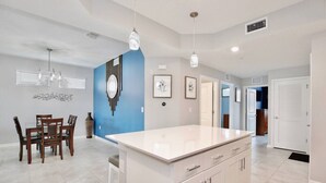 A modern kitchen with a central island, white cabinetry, and pendant lighting. - 3121-108 Resort Lake View Disney Universal Orlando (Kissimmee)