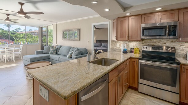 A modern kitchen with granite countertops, stainless steel appliances, and wooden cabinets.