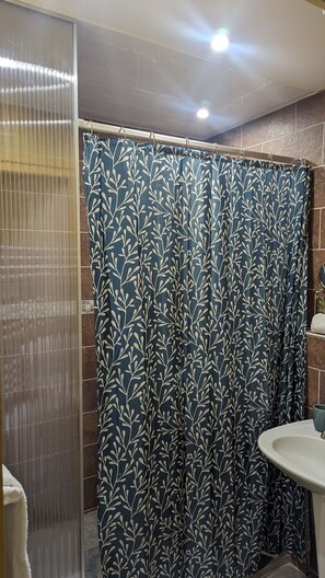 Comfort kamer | Badkamer | Een douche, een haardroger, handdoeken