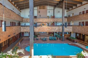 A multi-level indoor swimming pool with a brick floor and a central pool area. - 2 Condos | Pool, Hot Tub + Ski Bus (Crested Butte)