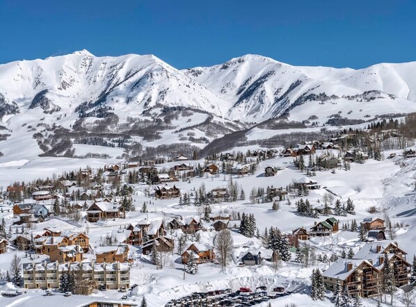 A snow-covered mountain town with wooden buildings and a clear blue sky. - 2 Condos | Pool, Hot Tub + Ski Bus (Crested Butte)