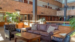 Un espace intérieur spacieux, avec un canapé en cuir marron, des fauteuils et une table basse en bois.