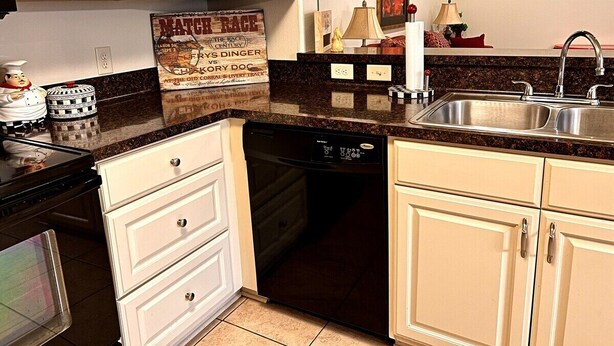A kitchen with white cabinets, a black dishwasher, a granite countertop, and a stainless steel sink. - Best Stays’ Ruby a Duplex, Pet Friendly, Work Crews family nurses

@‘ (Tyler)