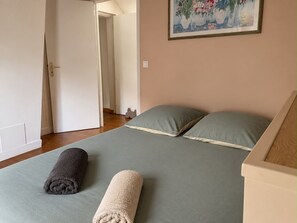 Ein Schlafzimmer mit einem Bett, Kissen und zwei gerollten Handtüchern.