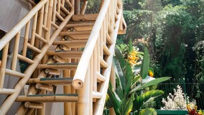 Una estructura de bambú con una escalera que lleva a una ventana.