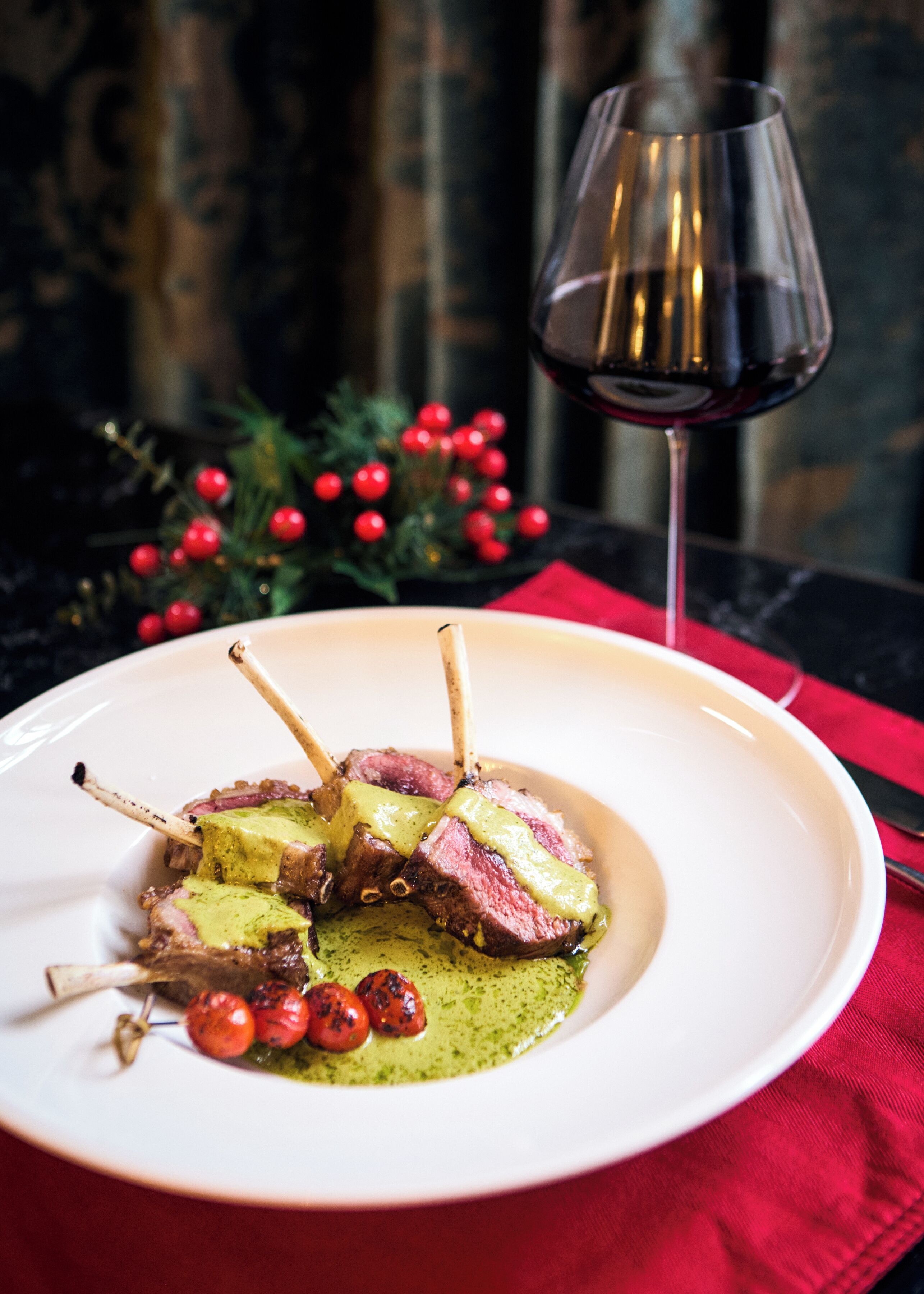 A plate of food with a glass of red wine and a red napkin.