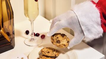 A festive table setting with a glass of champagne, cookies, and a Christmas card.