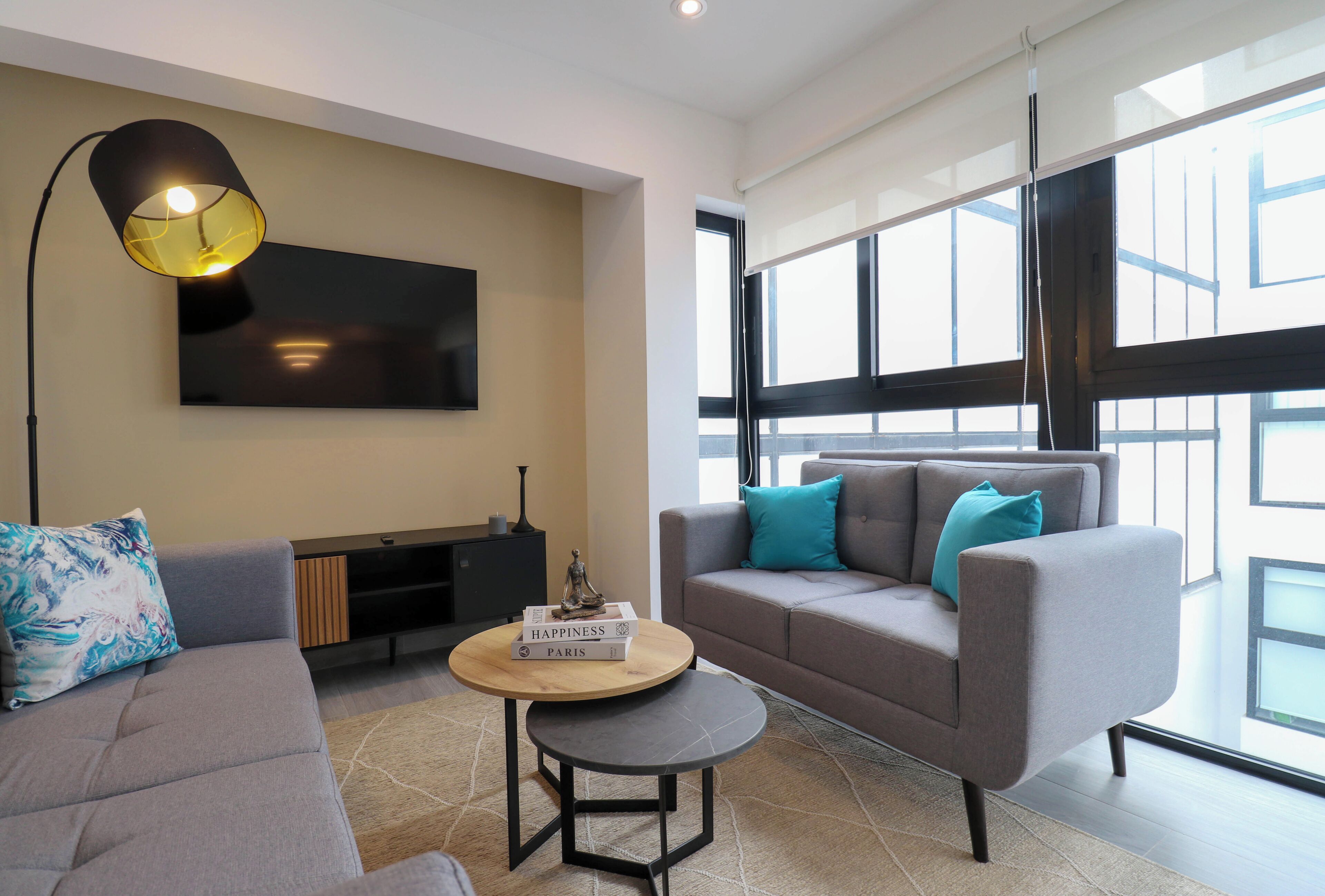 Un salon moderne avec un canapé, une table basse et un téléviseur fixé au mur.