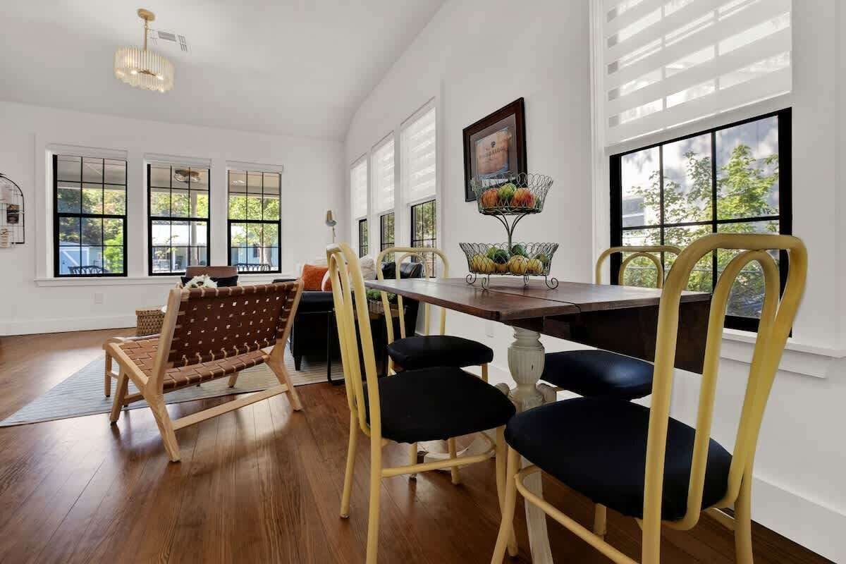 A dining area with a wooden table, yellow chairs, and a woven bench.
