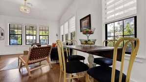 Un comedor con una mesa de madera, sillas amarillas y un banco tejido.