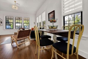 A dining area with a wooden table, yellow chairs, and a woven bench.