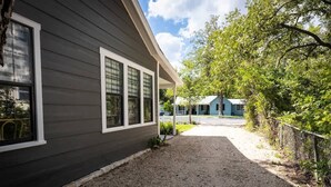 A house with a gravel driveway leading to a covered porch. - Creek's Edge Peaceful Retreat with Firepit (Fredericksburg)