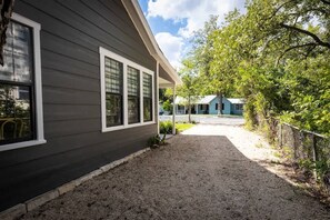 A house with a gravel driveway leading to a covered porch. - Creek's Edge Peaceful Retreat with Firepit (Fredericksburg)