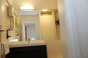A bathroom with a sink, mirror, and a shower area. - Floridianes Provence (Aix-en-Provence)