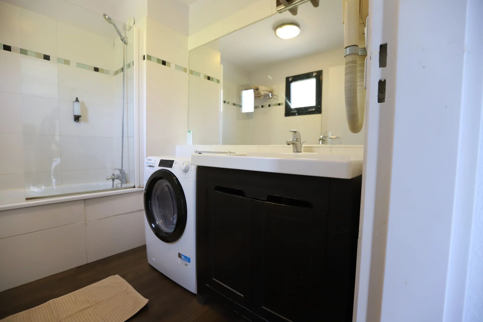 Un baño con lavadora, bañera y lavamanos.