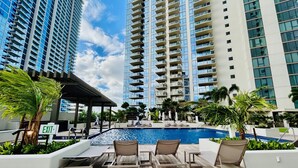 A rooftop pool area with lounge chairs and a sign indicating an exit.