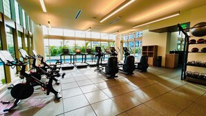 A gym with cardio machines, weight equipment, and a rack of helmets.