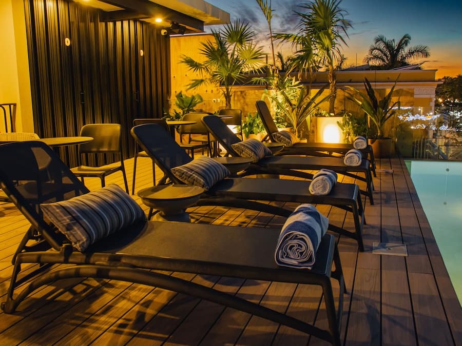 Una piscina al aire libre, sillones reclinables de piscina