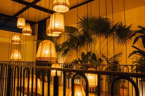 Una escalera con lámparas colgantes y plantas en macetas.