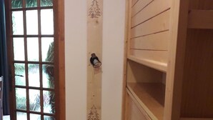 A narrow hallway with wooden walls and a wooden door with glass panels. - Appartement Pied des Pistes (Châtel)