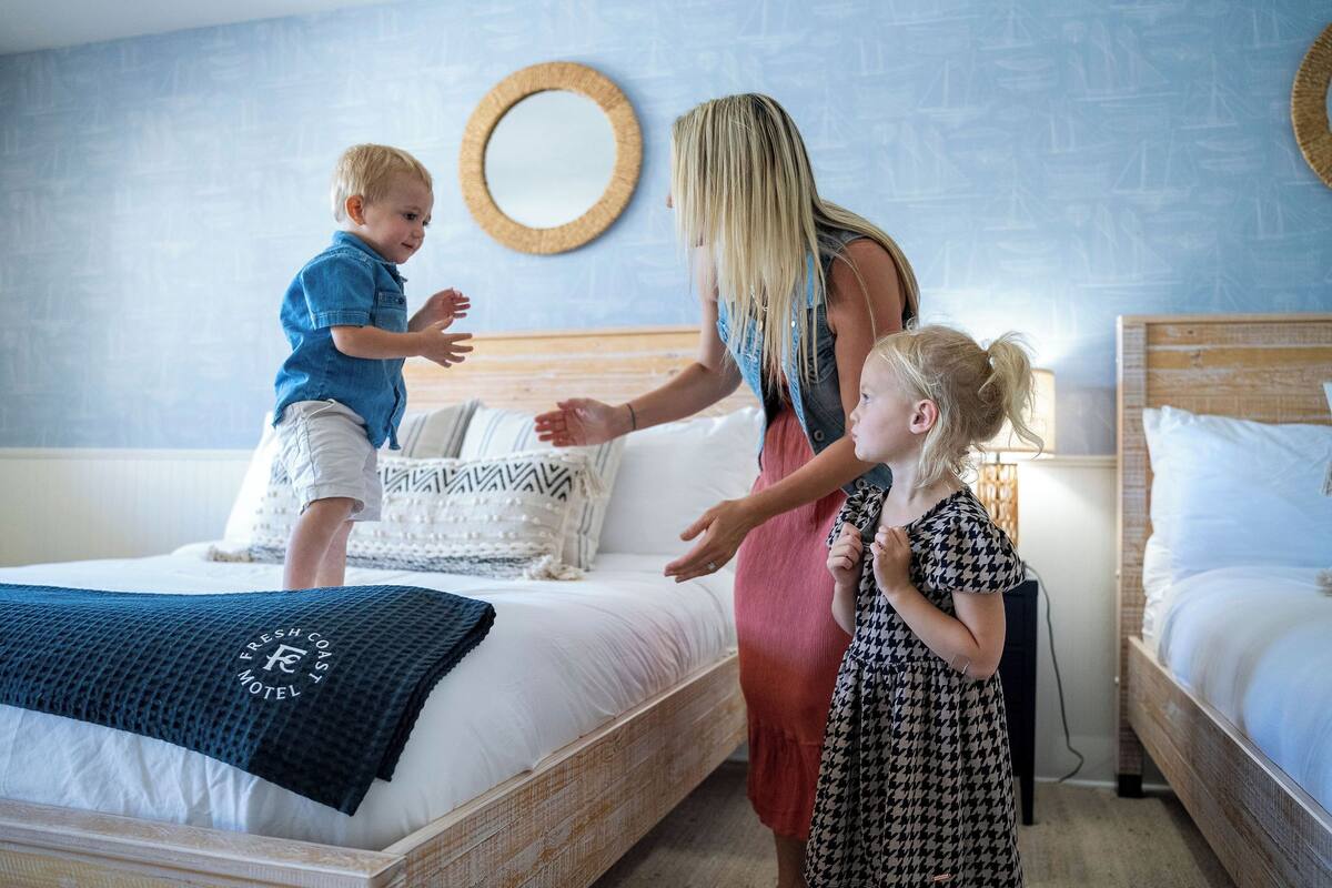 A bedroom with a bed, a bedside table, and a wall-mounted mirror.