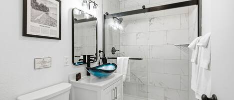 A bathroom with a toilet, sink, and shower.