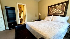 A bedroom with a bed, a bench, a wardrobe, and a painting on the wall. - BestStays@Bayou-Chic -work crews love us. Fenced with WIFI (Baton Rouge)