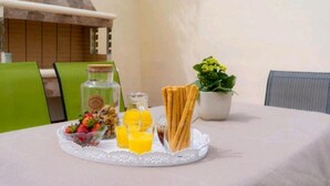 A breakfast tray with cereal, strawberries, orange juice, and toast on a table.