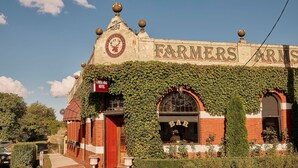 A building with ivy-covered walls, a sign reading 'Farmers Arms Hotel,' and a date '1857' on the top.