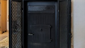A fireplace with a black door and decorative metal panels. - WaldHausen, free WiFi and Netflix (Mömlingen)