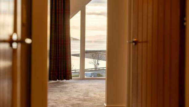 A corridor leading to a room with a view of a bridge and a body of water. - Cairn Cottage in the village of Onich (Onich)