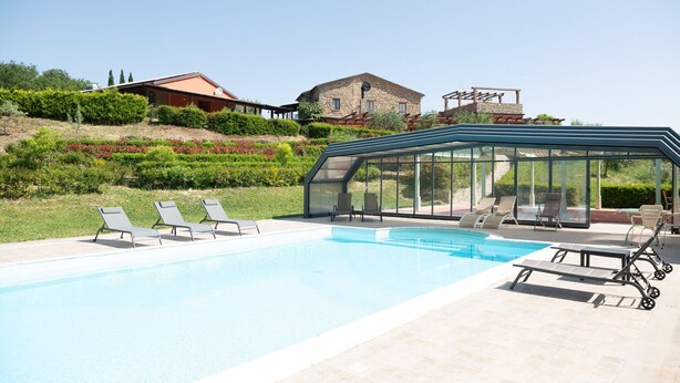 A swimming pool with lounge chairs and a glass-enclosed patio area. - Villa in Trivigno with 9 bedrooms sleeps 18 (Trivigno)
