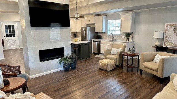 A spacious living room with a fireplace, a dining area, and a kitchen in the background. - Agreeable Gray: 3 Bedroom, Soothing 5 Beds, Large groups, Pet Friendly

 (Tyler)