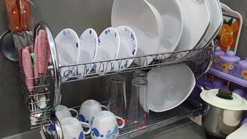 A kitchen with a dish rack holding plates, bowls, and cups.
