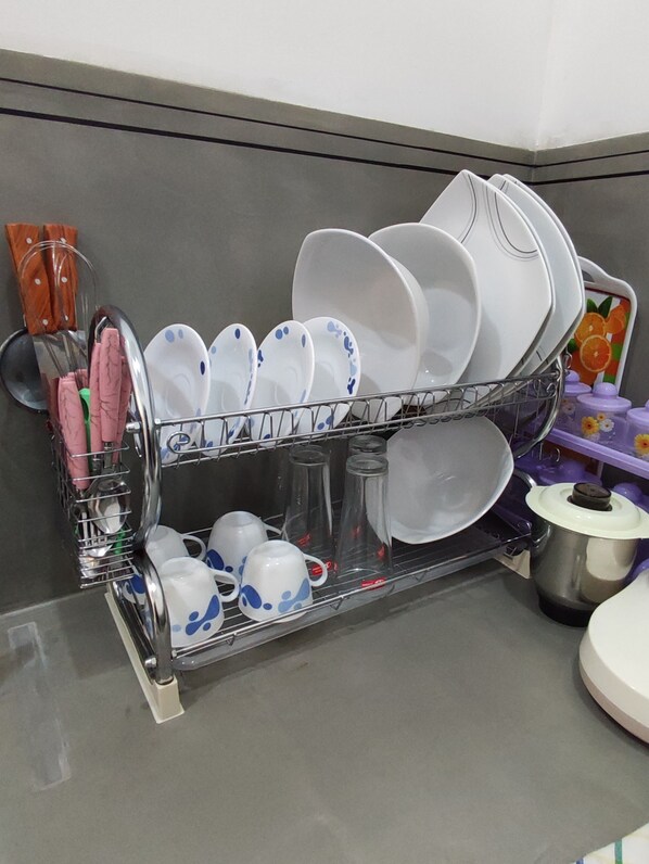 Una cocina con un escurreplatos que contiene platos, tazones y vasos.