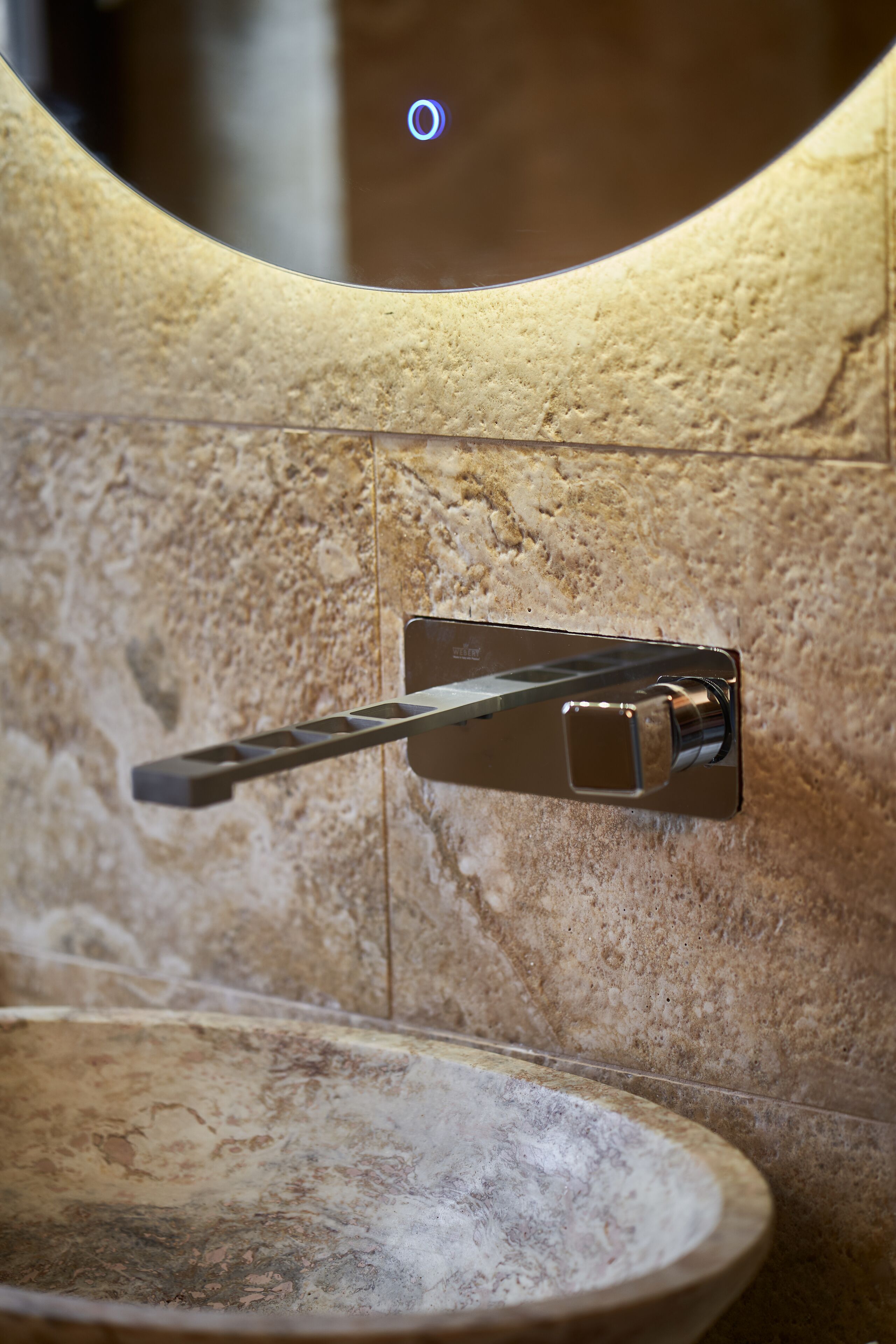 Un bagno con lavabo in pietra e rubinetteria cromata.