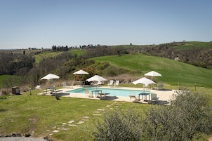 Una piscina al aire libre de temporada, sombrillas, tumbonas