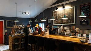 A café interior with a chalkboard menu, bar area, and seating.