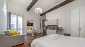 A modern hotel room with a bed, a sofa, a dining area, and a kitchen. - [Ghirlandina] Fantastic loft in the city center (Modena)