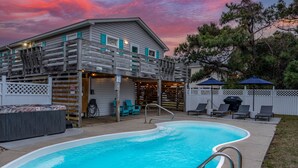 A swimming pool with a wooden deck, a hot tub, and outdoor seating. - New remodel! Walk to beach. Private heated pool & hot tub. Fenced yard. Dogs ok. (Nags Head)