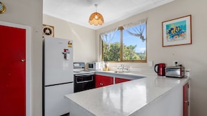 Una cocina compacta equipada con refrigerador, microondas, estufa y lavaplatos.