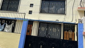 A multi-story building with a flat facade, multiple windows, and a gated entrance. - TOTY SUITE: Very quiet and familiar, with a panoramic view of the entire city (Quito)