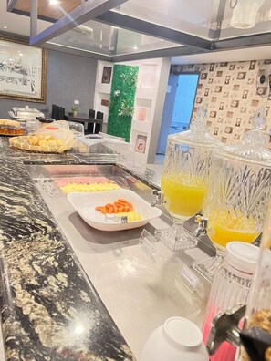 A buffet setup with various food items and a juice dispenser. - Itaipu Hotel (Foz do Iguaçu)