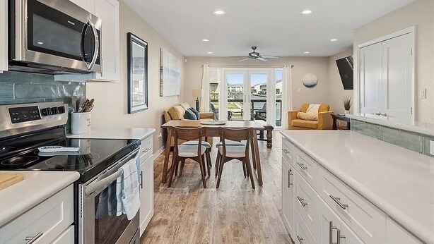 A modern kitchen with a dining area, large windows, and a view of the outdoors. - Waterfront Getaway with private boat slip on desirable Key Allegro, Rockport Tx (Rockport)