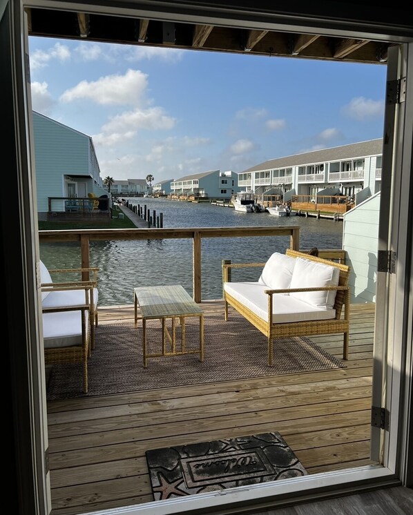 Enjoy the serene marina views from this deck with a wicker sofa and table.