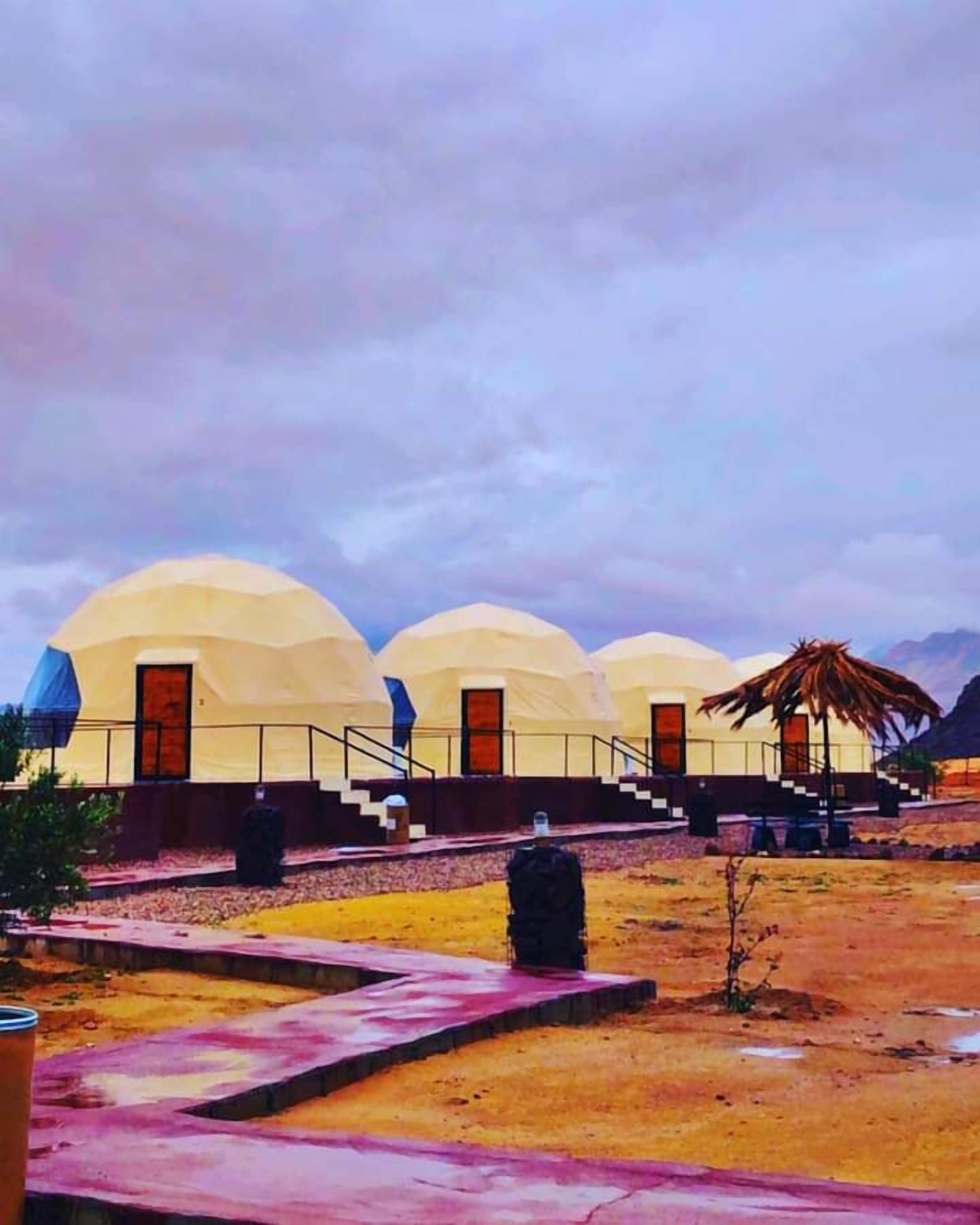 A series of dome-shaped buildings with a central staircase leading to a covered area.