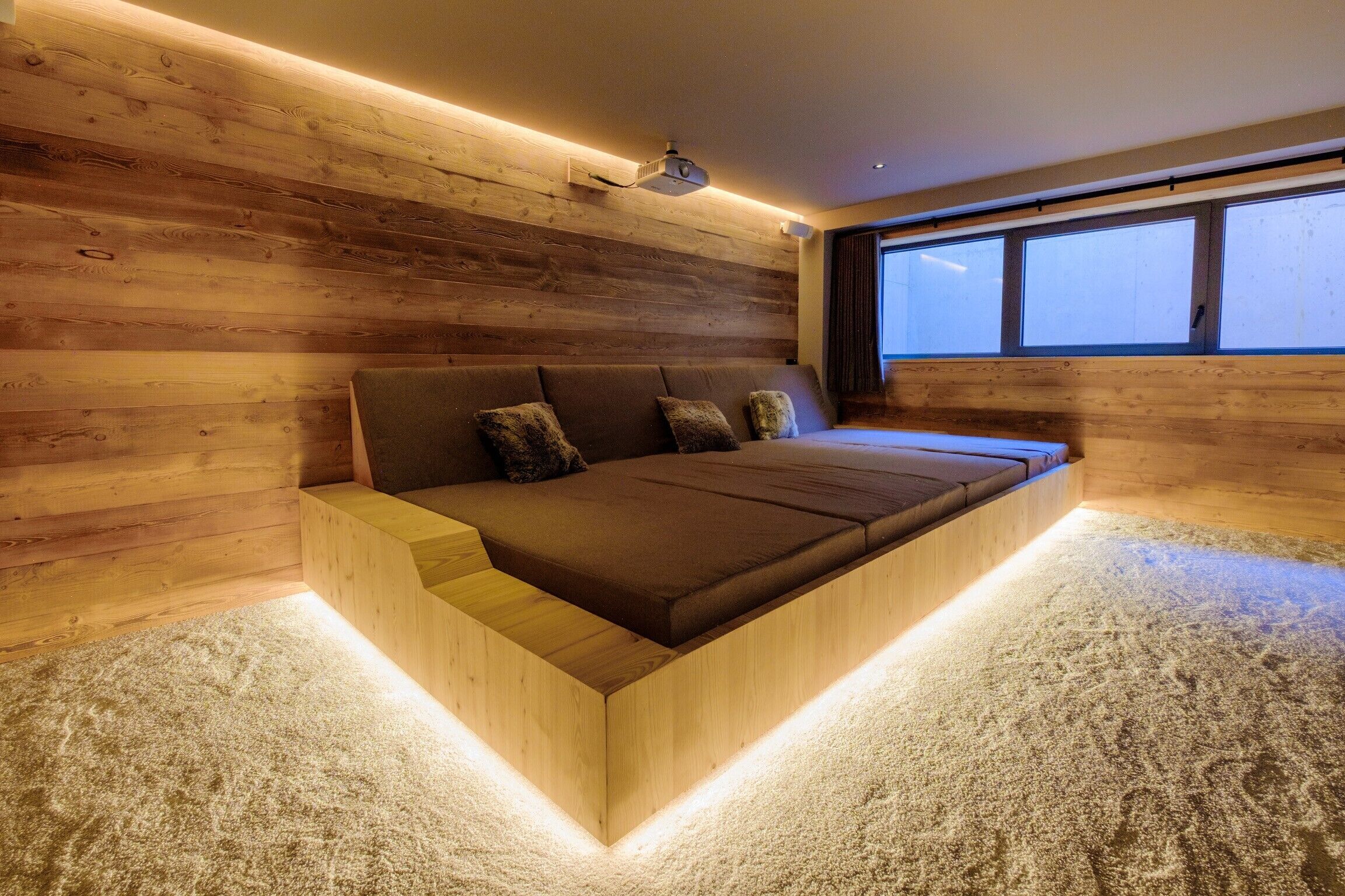 Une chambre moderne avec un mur en bois, un grand lit et une fenêtre.