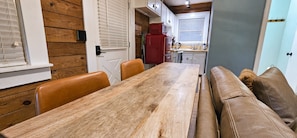 A compact kitchen with a red refrigerator, wooden cabinets, and a window with blinds. - Romantic Fall Foliage Couples Escape | Hot Tub, EV Charger, 600 Mbps (Mars Hill)